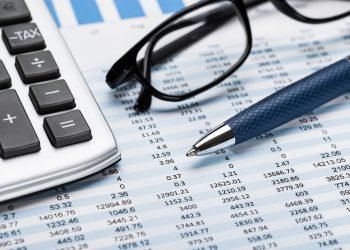 Close-up Of A Calculator With Pen And Eyeglasses On Data Sheet