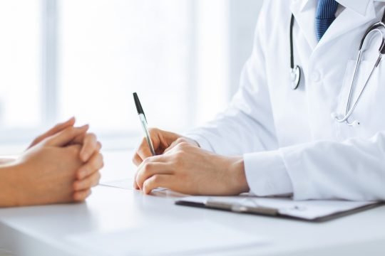 close up of patient and doctor taking notes