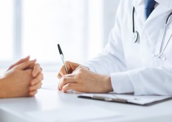 close up of patient and doctor taking notes